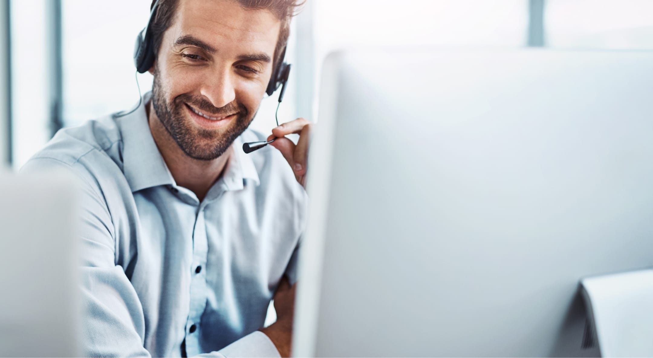 image of a guy behind a computer with a earpiece in helping a client